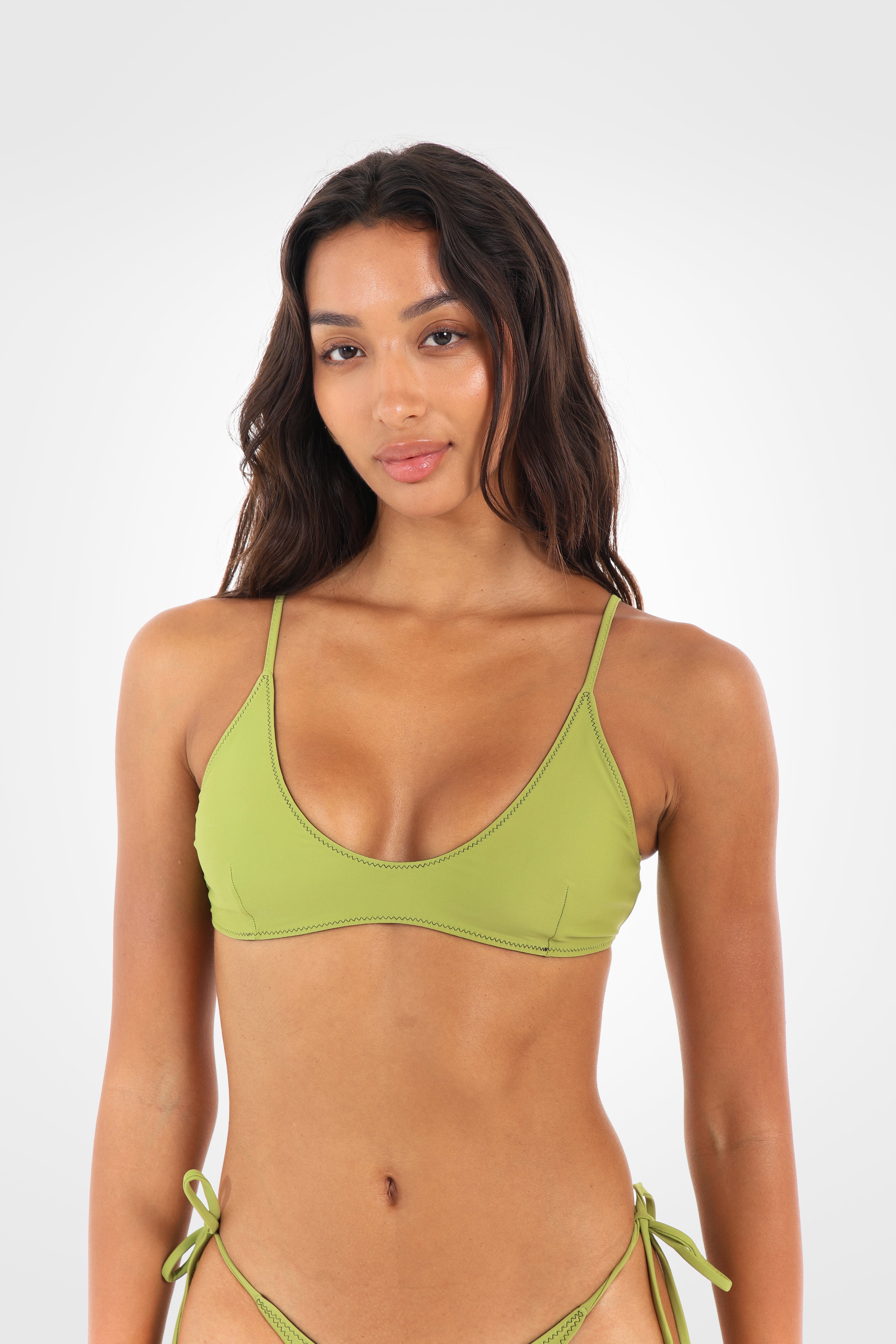 Close-up front view of the Aruna Reversible Scoop Bikini Top in pistachio green showcasing the scoop neckline and soft second-skin feel.