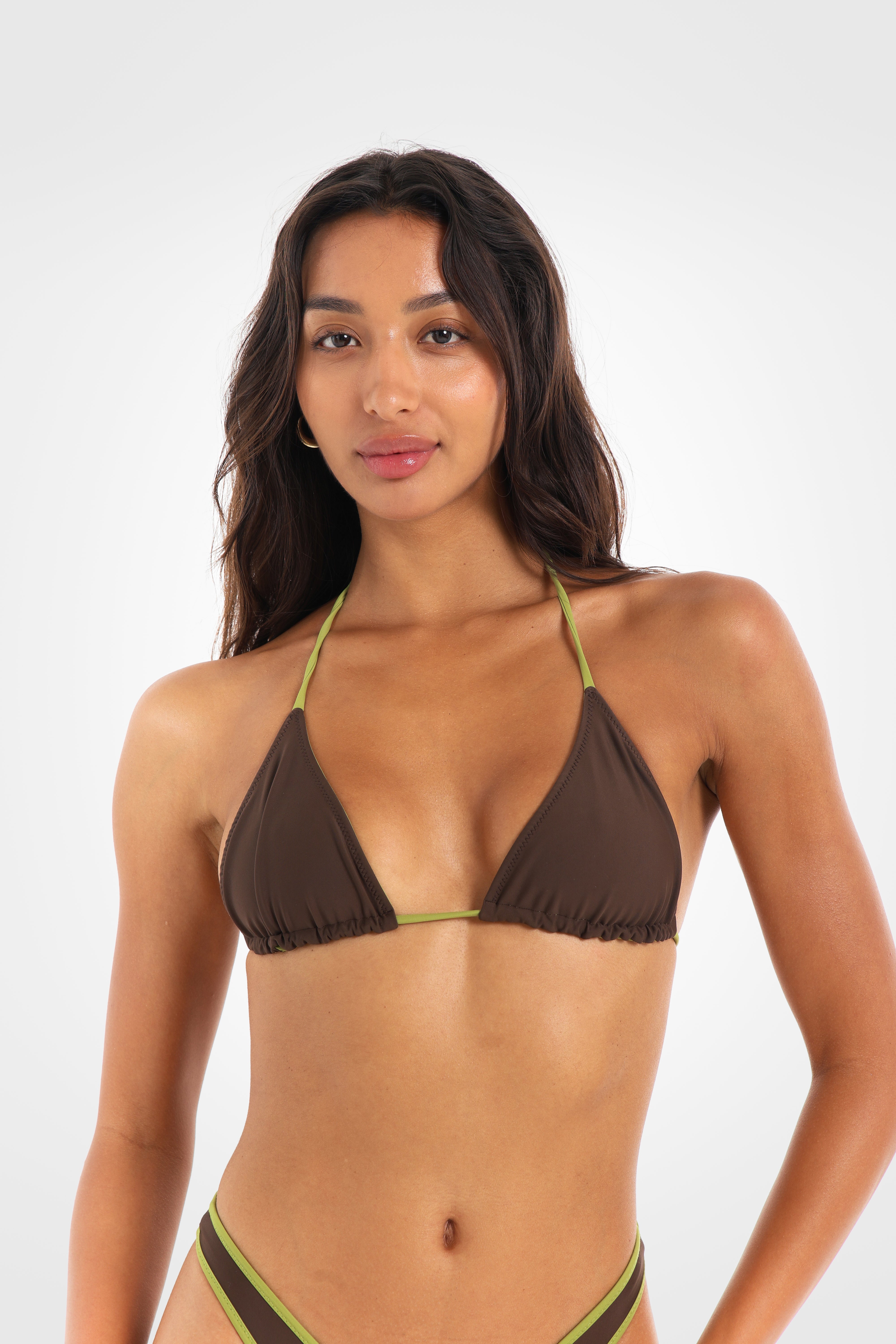 Close-up front view of the Aruna Reversible Triangle Bikini Top showcasing sliding triangle cups, pistachio-green contrast ties, and gold-finish tie ends.