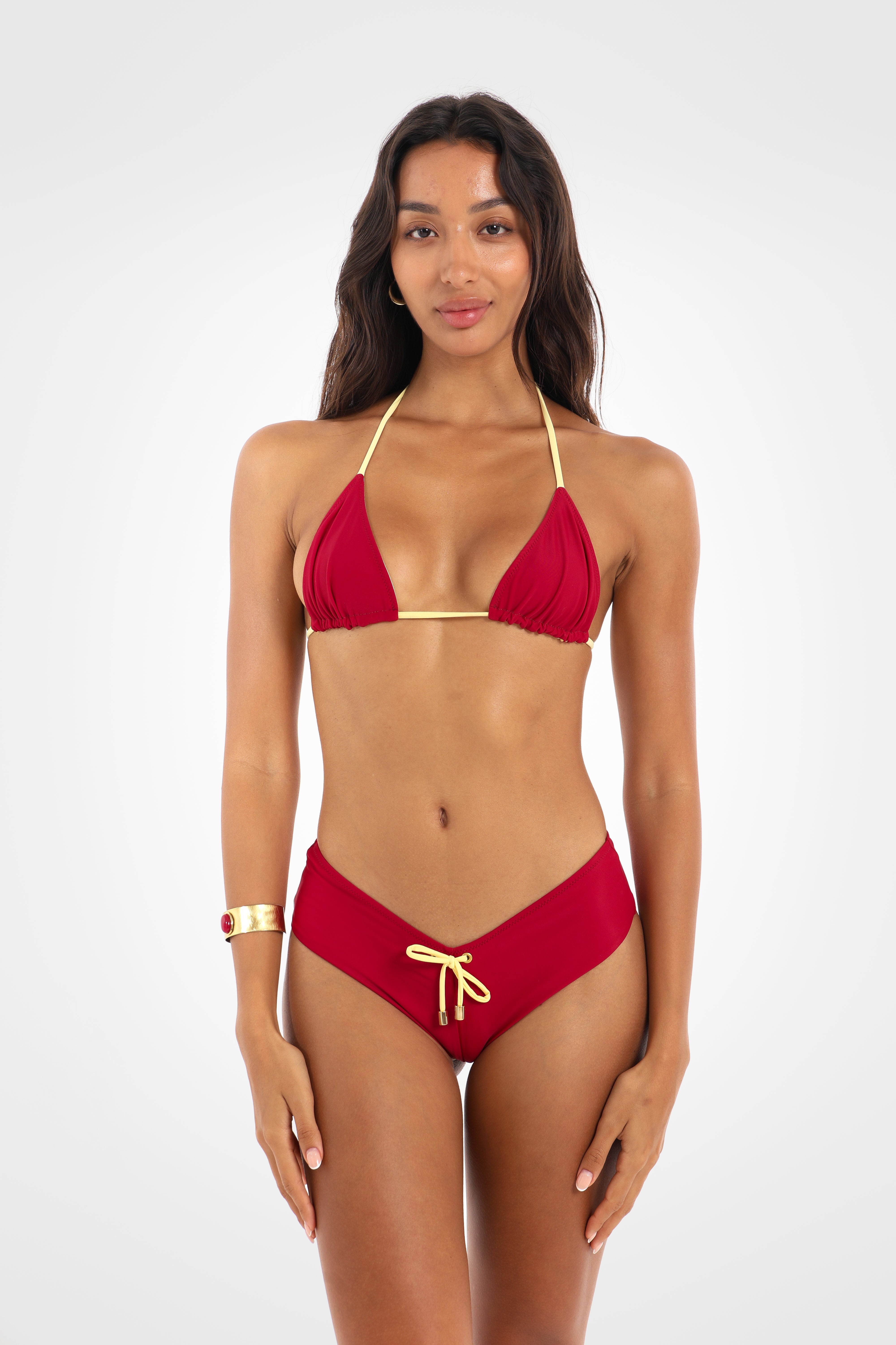 Front view of the Indra Cheeky Shortie Bikini Bottoms in rich berry red featuring a flattering V-front, decorative pastel yellow side bows, and a cheeky fit.