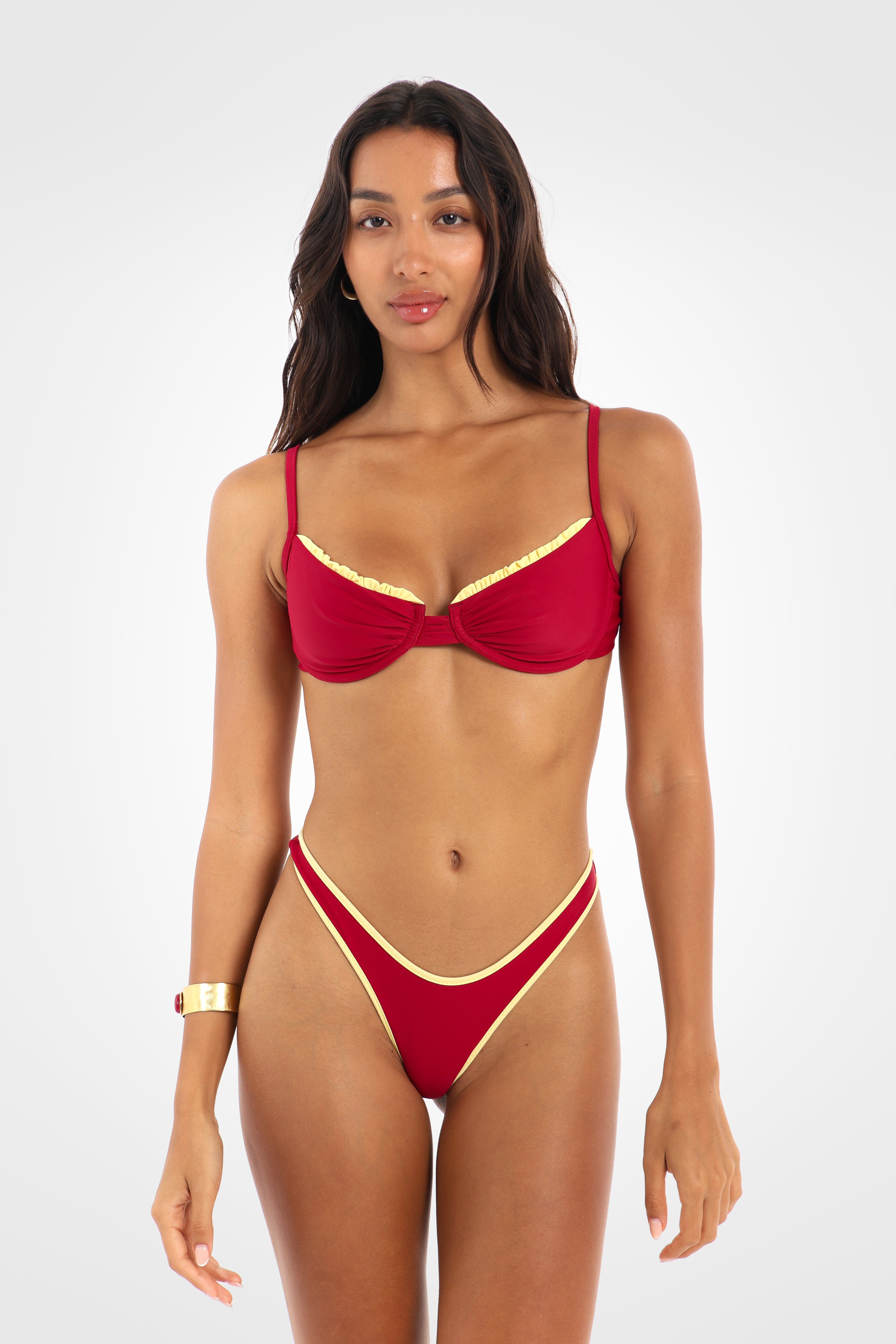Front view of the Indra Reversible Classic Low Coverage Bikini Bottoms in rich berry red featuring a high-cut silhouette, fixed sides, lemon yellow contrast binding, and a cheeky low coverage fit.