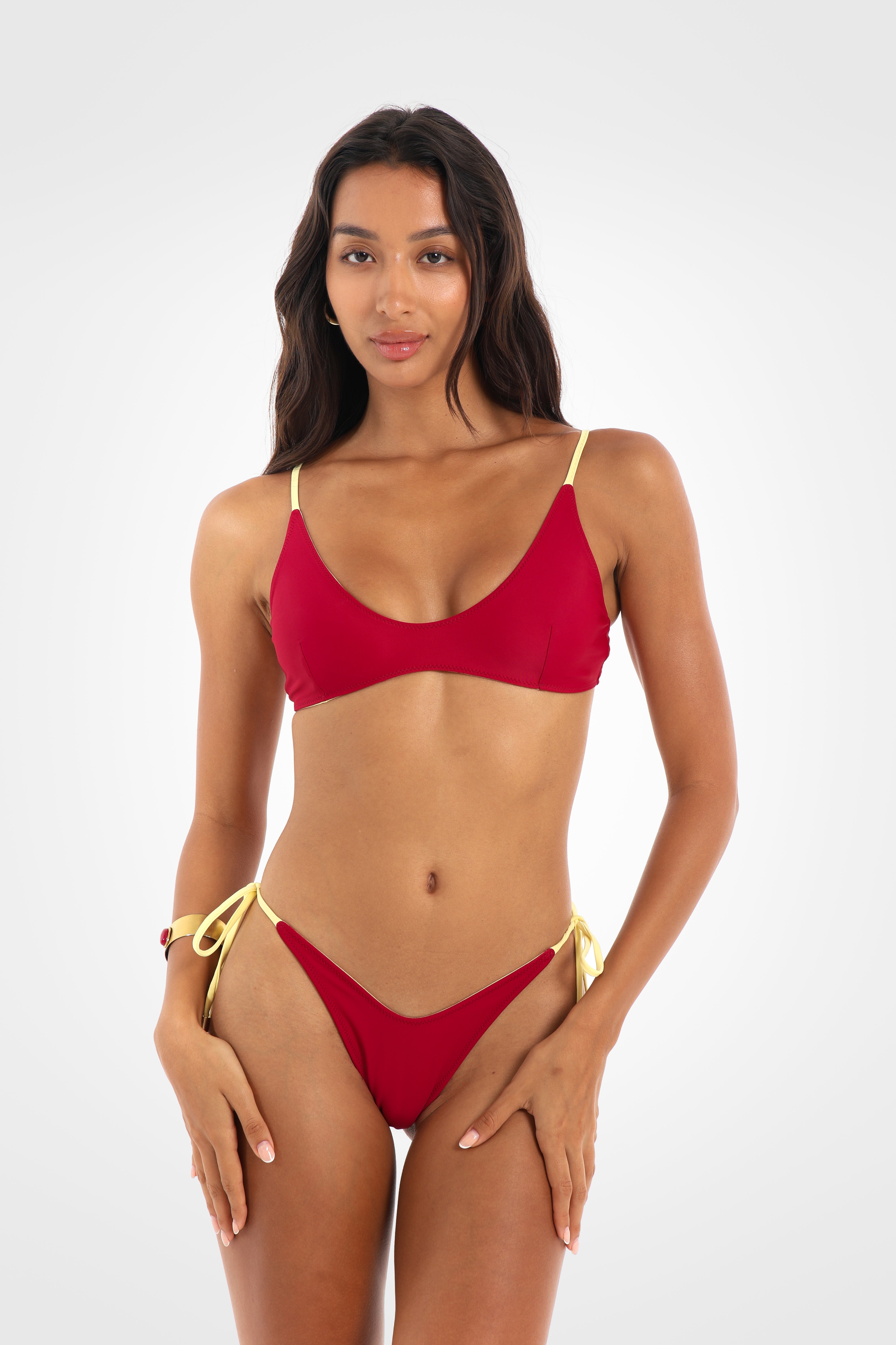 Front view of the Indra Reversible Scoop Bikini Top in rich berry red featuring a soft scoop neckline, slim lemon yellow straps, and an adjustable lace-up back.