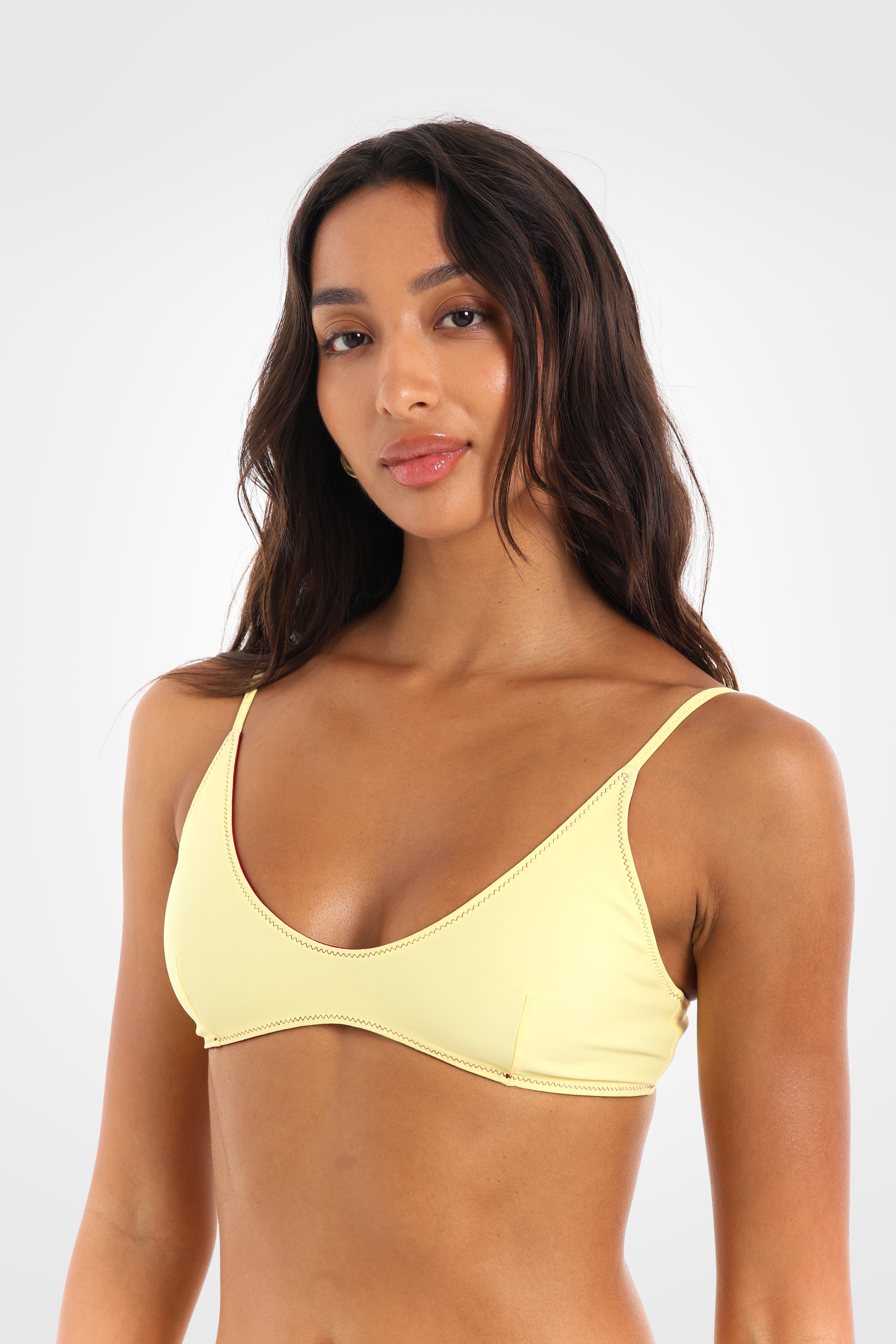 Close-up front view of the Indra Reversible Scoop Bikini Top in the lemon yellow reverse highlighting the flattering scoop neckline and clean, minimal silhouette.