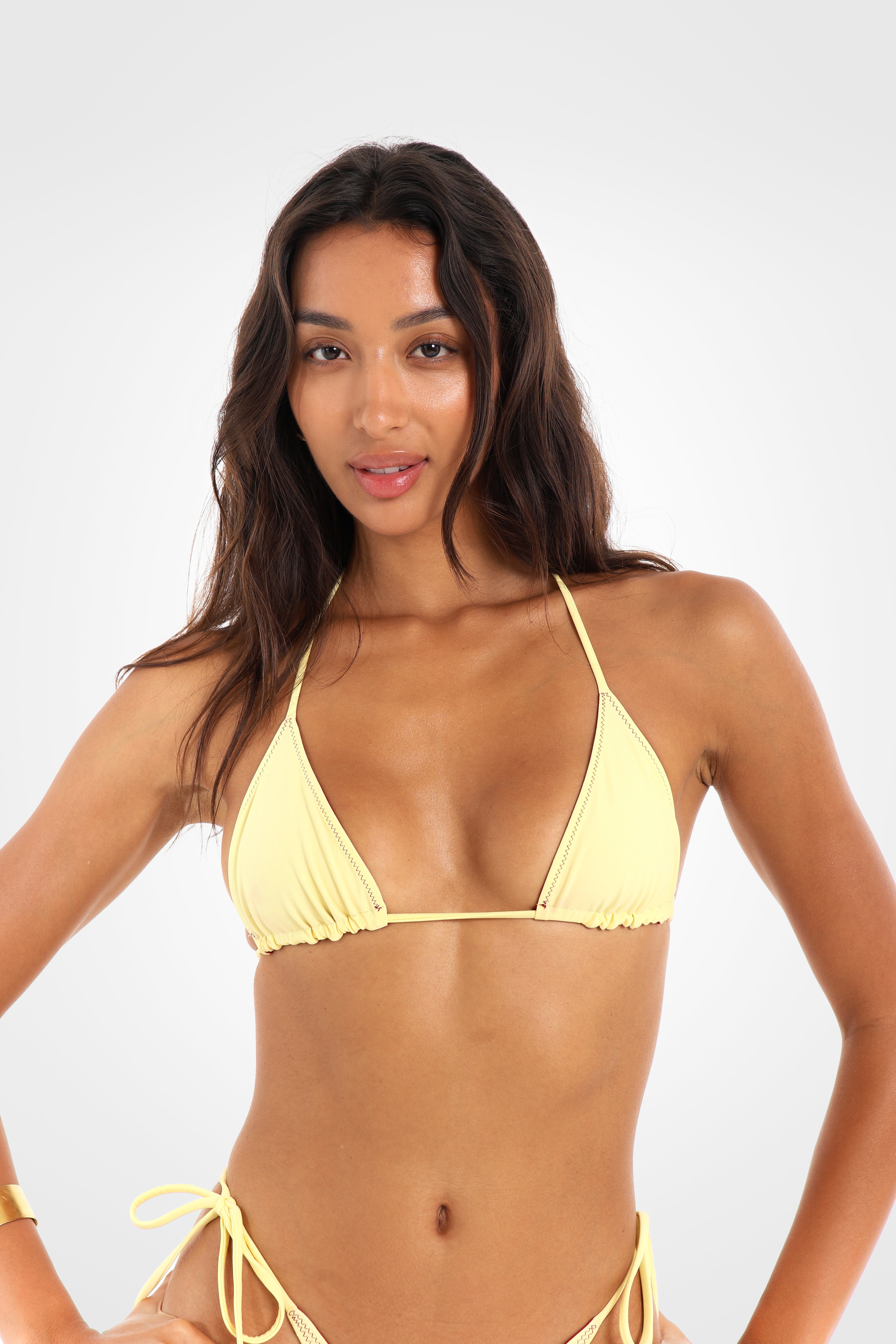 Close-up front view of the Indra Reversible Triangle Bikini Top in the lemon yellow reverse, showcasing the adjustable sliding triangle cups and clean triangle silhouette.
