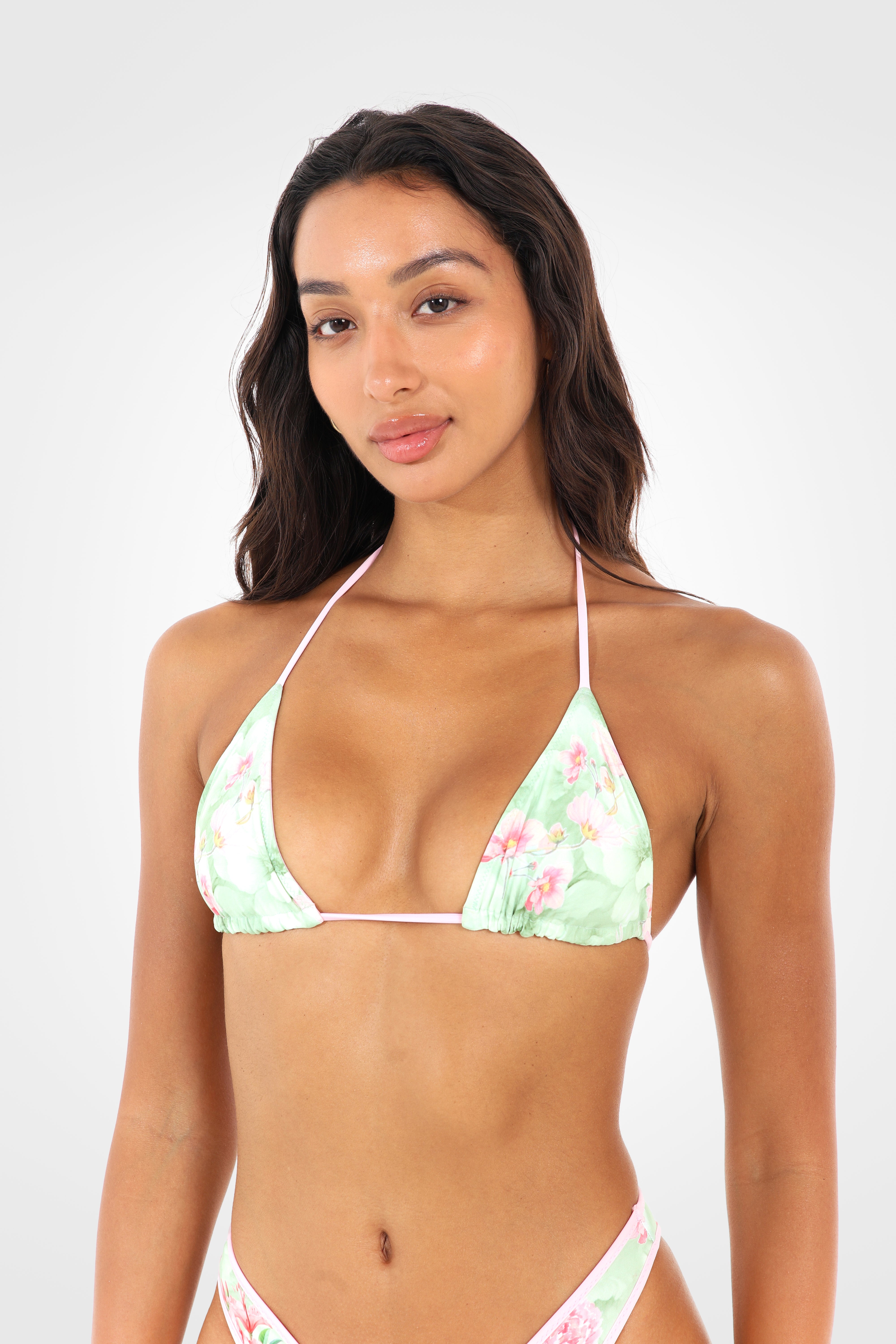 Close-up front view of the Lumira reversible triangle bikini top in pastel floral print with adjustable sliding triangle cups and contrast pink ties.